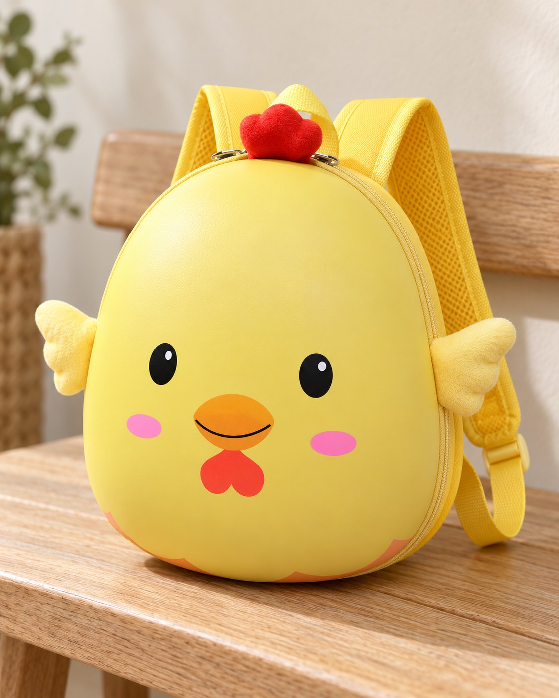 Yellow chick backpack on a light oak bench