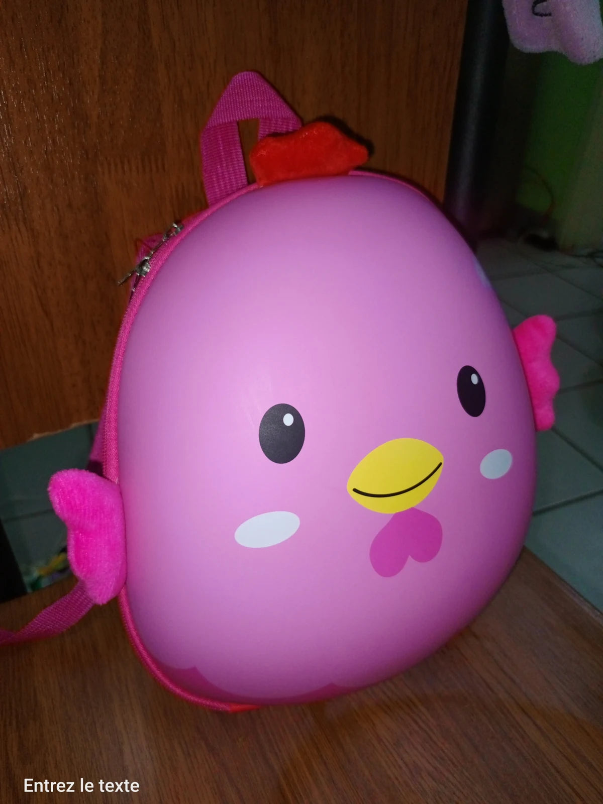 Customer-provided photo of the pink chick backpack on a wooden chair